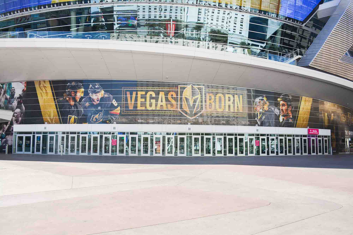 Large “VEGAS BORN” mural featuring Vegas Golden Knights players across the glass exterior of T-Mobile Arena.