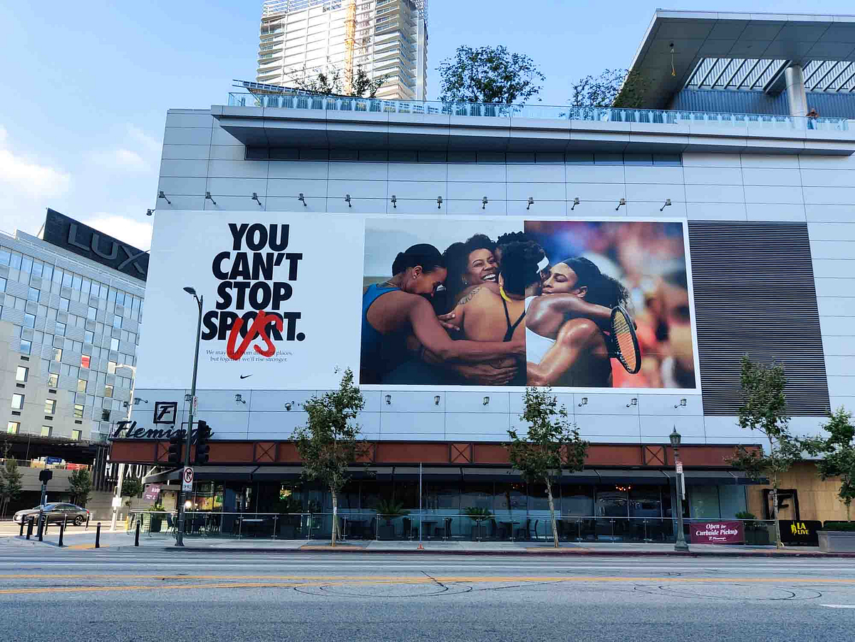 Nike billboard at LA Live featuring the phrase “You Can’t Stop Sport” and an image of athletes hugging.
